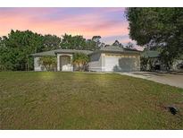 Charming single-story home featuring a well-maintained lawn and attached two car garage at 2495 De Garmo St, North Port, FL 34291