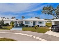Charming single-story home featuring a well-manicured lawn and bright blue accents on the shutters at 414 Circlewood Dr # H2, Venice, FL 34293