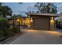 Modern home exterior with a gray brick driveway and a well-lit two-car garage at 425 Nassau S St, Venice, FL 34285