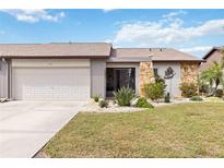 Inviting single-story home with attached garage and well-maintained lawn at 613 Chestnut Ln, Englewood, FL 34223