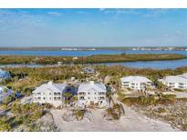 Aerial view showcases pristine beach houses and lush waterways, offering a serene coastal living experience at 7430 Palm Island Dr # 3813, Placida, FL 33946