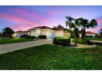Charming single-story home features a tile roof, lush landscaping, and an attached two-car garage at 8356 Creekview Ln, Englewood, FL 34224