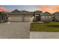 Beautiful single-story home with a three car garage and a well manicured lawn at 8562 Shore Lake Dr, Englewood, FL 34224