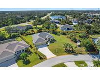 A well-maintained single-Gathering home with a spacious lawn, a driveway, and a boat on the right side of the property at 9087 Hilliard Ter, Englewood, FL 34224