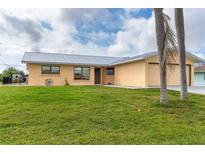 Charming single-story home with a well-maintained lawn, a metal roof and mature landscaping at 10075 Bentley Ave, Englewood, FL 34224