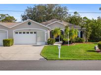 Charming single-story home with well-manicured lawn and attached two car garage at 1332 Hedgewood Cir, North Port, FL 34288
