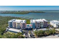 Waterfront condo building with vibrant colors, community pool, and boat docks offers a relaxed coastal lifestyle at 1410 Beach Rd # 201, Englewood, FL 34223