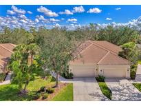 Beautiful single-Gathering home with a well-manicured lawn, mature trees, and a two-car garage at 14298 Reserve Ct, Port Charlotte, FL 33953
