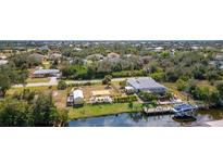 Aerial view showcasing home with waterfront access, private dock, boat, and outdoor entertaining at 14382 Lillian Cir, Port Charlotte, FL 33981