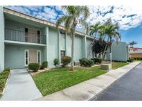 Inviting condominium featuring a well-manicured lawn with several palm trees at 1461 Aqui Esta Dr # B3, Punta Gorda, FL 33950