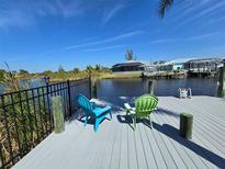 Waterfront home with a private dock and chairs overlooking the canal at 14970 Appleton Blvd, Port Charlotte, FL 33981