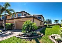 Charming two-story townhome with a tile roof, attached garage, and lush landscaping at 20110 Ragazza Cir # 102, Venice, FL 34293