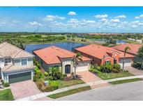 Beautiful homes with brick driveways, well-manicured lawns, and serene lake views creating a picturesque setting at 23781 Waverly Cir, Venice, FL 34293