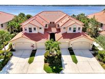 Stunning aerial view of the Mediterranean-style home showcasing the red tile roof and lush landscaping near the water at 4624 Club Dr # G201, Port Charlotte, FL 33953