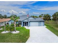 Charming single-story home with well-manicured lawn, palm trees, and a spacious three-car garage at 59 Long Meadow Ln, Rotonda West, FL 33947
