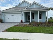 Charming single Gathering home features a two car garage, neutral paint, and manicured lawn at 8375 E Windbound Ct Ct, Sarasota, FL 34240