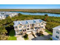 Beautiful exterior view of a multi-level townhouse with a metal roof and stunning water views at 10310 Coral Landings Ct # 98, Placida, FL 33946