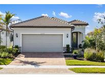 Charming single-Gathering home featuring a brick driveway, tile roof, and well-maintained landscaping at 13137 Oriago St, Venice, FL 34293