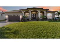 Charming single-story home featuring a well-manicured lawn and inviting front entrance with decorative pillars at 15578 Seafoam Cir, Port Charlotte, FL 33981