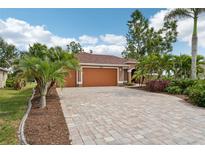 Charming single-story home featuring a paver driveway, lush landscaping, and a welcoming two-car garage at 16137 Alcira Cir, Punta Gorda, FL 33955