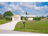 Charming single-story home with a well-manicured lawn, mature landscaping, and a two-car garage, enhancing its curb appeal at 2545 Geneva Rd, Venice, FL 34293