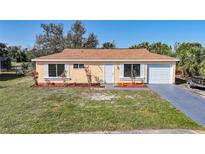 Charming one-story home with a well-manicured lawn and attached one car garage at 5881 Talbrook Rd, North Port, FL 34287