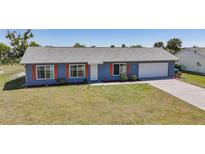 Charming single-story home with a well-maintained lawn and colorful landscaping at 6318 Coniston St, Port Charlotte, FL 33981