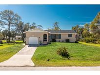 Charming single-story home featuring a well-manicured lawn and an attached garage at 8159 Archie St, Englewood, FL 34224