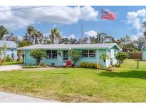 Charming single-story home featuring a well-maintained lawn, mature landscaping, and an American flag at 849 Palmetto St, Englewood, FL 34223