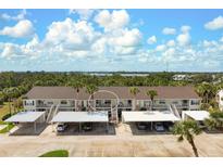 Beautiful condo building with covered parking and lush landscaping at 202 Silver Lake Dr # 203, Venice, FL 34292