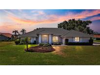 Stunning single-story home featuring a lush lawn and meticulously landscaped garden beds at 217 Rockwood Way, Englewood, FL 34223