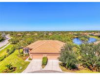 Beautiful lakefront property with lush landscaping, barrel tile roof, and a two-car garage at 2625 Wax Myrtle, Port Charlotte, FL 33953