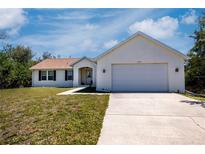Charming single-story home with a two-car garage, well-manicured lawn, and inviting curb appeal at 6368 Pennell St, Englewood, FL 34224