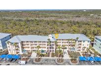 Condo building featuring balconies, covered parking and tropical landscaping at 8409 Placida Rd # 305, Placida, FL 33946