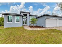 Charming single-story home with a manicured lawn and attached two-car garage at 10782 Kearsarge Cir, Port Charlotte, FL 33981