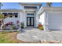 Beautiful single Gathering home featuring a well-manicured lawn, stone accents and a covered front entryway at 13379 Journal Ln, Port Charlotte, FL 33981