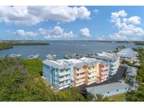 Aerial view of multi-colored condominiums with water views, marina, and green space at 1420 Beach Rd # 203, Englewood, FL 34223