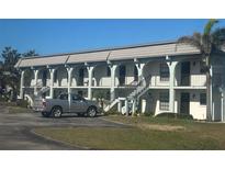 Multi-Gathering home with a tile roof, arches, staircases, and a silver truck in the driveway at 150 Englewood Isles Pkwy # 201, Englewood, FL 34223