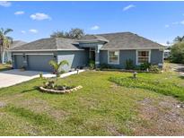 Charming single-story home featuring a well-manicured lawn and a two-car garage at 15251 Appleton Blvd, Port Charlotte, FL 33981