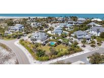 Beautiful aerial view of coastal homes with lush tropical landscaping near white sandy beaches and blue water at 16251 Sunset Pines Cir, Boca Grande, FL 33921