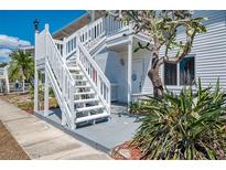 Charming exterior featuring white wooden stairs and a well-maintained landscape at 200 Rotonda W Blvd # A2, Rotonda West, FL 33947
