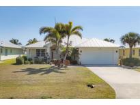 Charming single-story home with a metal roof, lush landscaping and inviting curb appeal at 25 Medalist Ter, Rotonda West, FL 33947