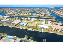 Stunning aerial view of waterfront homes along canals with boat docks and ocean access in a desirable neighborhood at 471 Capri Isles Ct, Punta Gorda, FL 33950