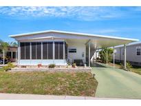 Charming single-story home with a covered carport and screened porch, surrounded by lush landscaping at 5619 Bayshore Rd # 240, Palmetto, FL 34221