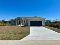 Charming single-story home features a two-car garage, well-maintained lawn, and a concrete driveway at 9172 Ravel St, Port Charlotte, FL 33981