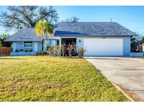 Charming single-story home boasts a well-manicured lawn, palm tree, and a two-car garage at 10299 Willmington Blvd, Englewood, FL 34224
