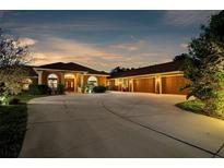 Stunning exterior shot of a home with a large driveway, well-lit facade, and attached three-car garage at 103 Mecca St, Port Charlotte, FL 33954