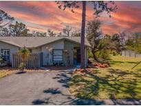 Charming one-story home featuring a well-manicured lawn and a paved driveway against a vibrant sunset backdrop at 107 Jose Gaspar Dr, Englewood, FL 34223