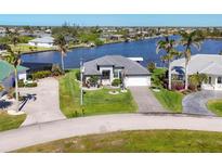 Inviting single-story home with a well-maintained lawn and waterfront views at 15498 Seafoam Cir, Port Charlotte, FL 33981