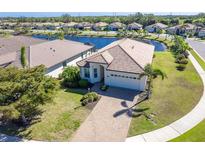 Beautiful single-story home with a well-manicured lawn and a stunning lake view at 156 Nolen Dr, Venice, FL 34292